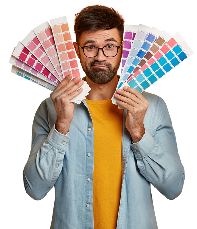 Un graphiste de Nerd Marketing entouré de nuanciers de couleurs